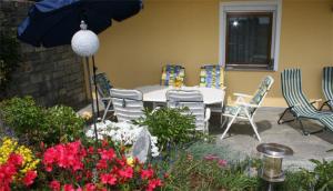 une terrasse avec une table, des chaises et un parasol dans l'établissement Ferienwohnung Tahedl, à Wegscheid