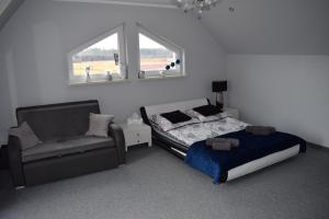 a bedroom with a bed and a chair and a window at Agroturystyka nad Nidą in Włoszczowa