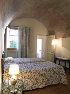 1 dormitorio con 1 cama y 1 mesa con 2 lámparas en Appartamento Frantoio, en San Miniato
