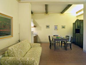 a living room with a couch and a table with chairs at Appartamento Frantoio in San Miniato