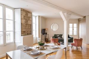 - un salon avec une table et des chaises blanches dans l'établissement La Tourelle & l'Honoré - 2 appartements dans le Centre historique de Rennes, à Rennes