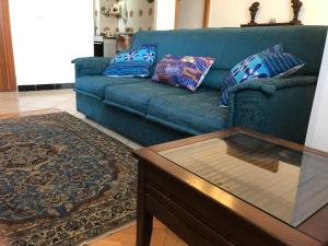 um sofá azul com almofadas e uma mesa de centro na sala de estar em Stella Di Mare - ampio appartamento con doppi servizi - fronte mare em Lido di Ostia