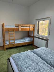 a bedroom with two bunk beds and a window at Penthouse perfekt für Teams, Familien und Gruppen in Bad Mergentheim