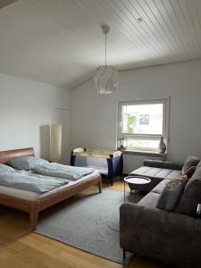 a living room with two beds and a couch at Penthouse perfekt für Teams, Familien und Gruppen in Bad Mergentheim