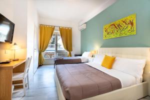 Habitación de hotel con 2 camas, escritorio y TV. en Aurelia Home Guest House en Roma