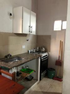 a small kitchen with a sink and a stove at Don Pocho in Mar de Ajó