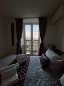 a bedroom with a bed and a large window at Montesanto 77 casa panoramica al centro storico in Naples