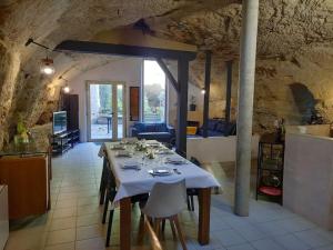 uma mesa de jantar num quarto com uma cozinha em Maison troglodytique Doué La Fontaine em Doué-la-Fontaine