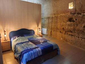 um quarto com uma cama azul num quarto em Maison troglodytique Doué La Fontaine em Doué-la-Fontaine