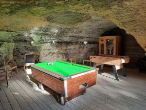a room with a pool table in a cave at Maison troglodytique Doué La Fontaine in Doué-la-Fontaine
