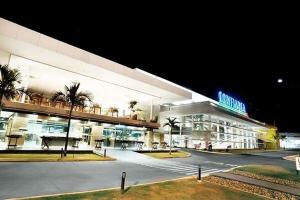 un grand bâtiment avec des palmiers devant lui dans l'établissement Ótima localização a 600 m shopping Esmeralda, à Marília