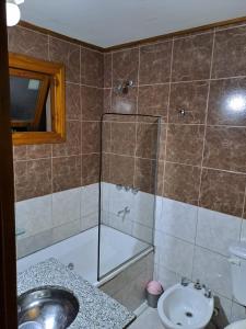 a bathroom with a shower and a sink and a toilet at Hermoso departamento vivi Bariloche todo el año in San Carlos de Bariloche