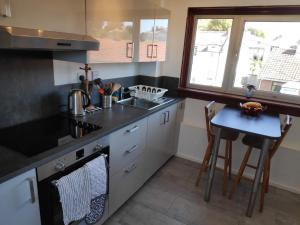 a kitchen with a sink and a stove top oven at Lovely 2BD Flat in picturesque Limekilns Fife in Limekilns