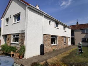 a white brick house with a window at Lovely 2BD Flat in picturesque Limekilns Fife in Limekilns