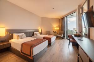 una camera d'albergo con 2 letti e una scrivania di Hotel Pia Bella a Kyrenia