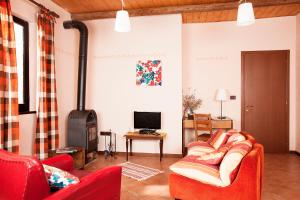 a living room with red chairs and a wood stove at Agriturismo Bufano in Cagli