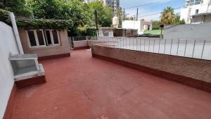 un patio de ladrillo rojo con una valla blanca en VI&VI HOSTEL MENDOZA en Mendoza