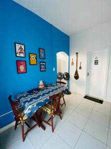 a dining room with a blue wall and a table at Rota BH Hostel in Belo Horizonte