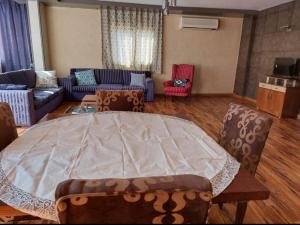 uma sala de estar com uma grande mesa e cadeiras em Family residence in the best location no Cairo