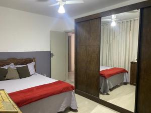 Apartamento Diamante في ديامانتينا: غرفة نوم بسريرين ومرآة كبيرة