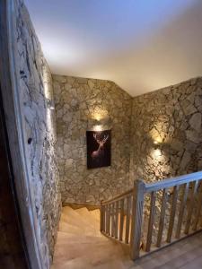 a room with a staircase with a stone wall at Le joli bois 12 personnes 5/ch spa/sauna Gérardmer in Gérardmer