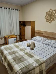 a bedroom with a large bed with a checkered blanket at POUSADA PATRIMÔNIO DOS SONHOS in PatrimÃ´nio da Penha