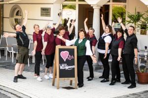 a group of people standing around a sign with their hands in the air at AKZENT Hotel Bayerwald-Residenz in Neukirchen