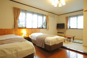 En eller flere senge i et værelse på HakubaGoryu Pension&LogCottage Arumu
