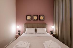 1 dormitorio con 1 cama grande y 2 toallas. en Exarcheia Vibe Penthouse 1 en Atenas
