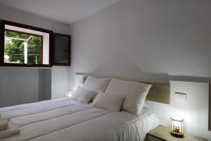 a bedroom with a large white bed with a window at Valley views apartment in Agaete in Agaete