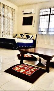 a bedroom with a bed and a table and a rug at SUPER COMFY HOME @ KULIM CITY in Kulim