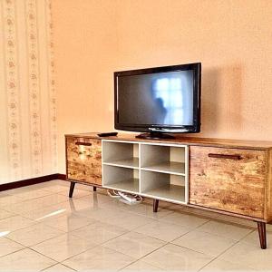 een flatscreen-tv bovenop een houten entertainmentcentrum bij SUPER COMFY HOME @ KULIM CITY in Kulim