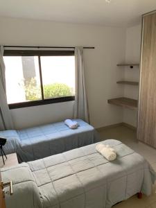 a bedroom with two beds and a large window at Moreno Park Complejo Residencial 1 in Ciudad Lujan de Cuyo