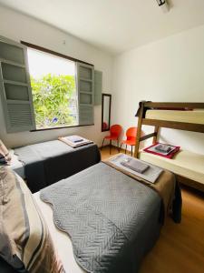 a room with two beds and a window at Rota BH Hostel in Belo Horizonte