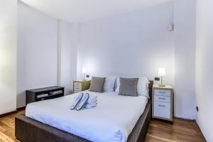 1 dormitorio con 1 cama blanca grande y 2 lámparas en BePlace Apartments in Dateo, en Milán