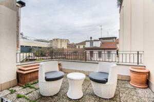 2 sillas y un taburete en un balcón en BePlace Apartments in Dateo, en Milán