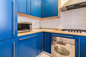cocina azul con armarios azules y fogones en BePlace Apartments in Dateo, en Milán