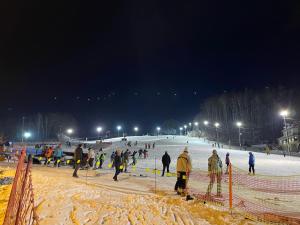 a group of people on a ski slope at night at Las i woda in Przywidz