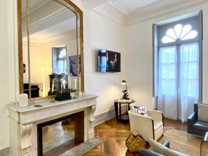 ein Wohnzimmer mit einem Kamin und einem großen Spiegel in der Unterkunft L'empereur - Parking - Fibre - Netflix in Montauban