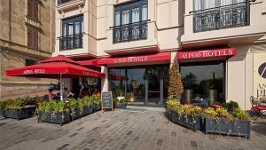Aspera Hotel Golden Horn في إسطنبول: مطعم فيه مظلات حمراء امام مبنى