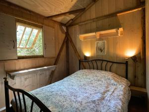 sypialnia z łóżkiem w pokoju z oknem w obiekcie Les Chalets de Labeaume w mieście Labeaume +37 zdjęć