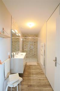 La salle de bains blanche est pourvue d'un lavabo et d'une douche. dans l'établissement LES BOIS DE CHAMPAGNE NORDIQUE, à Magnant
