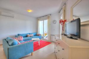 a living room with a blue couch and a flat screen tv at Casa Anchoa-A Murcia Holiday Rentals Property in Roldán