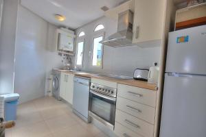 a kitchen with white appliances and a white refrigerator at Casa Anchoa-A Murcia Holiday Rentals Property in Roldán +10 photos