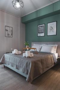 ein Schlafzimmer mit einem großen Bett und einer grünen Wand in der Unterkunft Casa bonita in the center of Volos in Volos