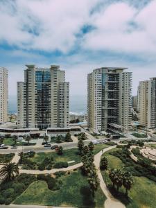 z góry widok na miasto z wysokimi budynkami w obiekcie Departamento en Costas de Montemar, a pasos de la playa, con Vista al Mar, Piscina y GYM w mieście Valparaíso