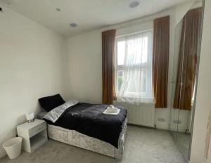 Seven Kings的住宿－Home in Ilford，一间卧室设有一张床和一个大窗户