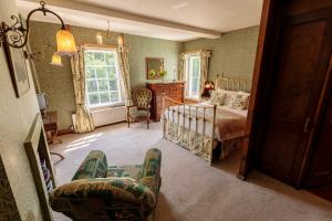a bedroom with a bed and a woman sitting in a chair at Hodgkinsons Hotel Matlock Bath in Matlock