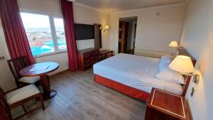 una camera d'albergo con un letto e una grande finestra di Hotel Diego de Almagro Punta Arenas a Punta Arenas