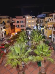 a group of palm trees in a city at night at Hotel Sylesia in Letojanni